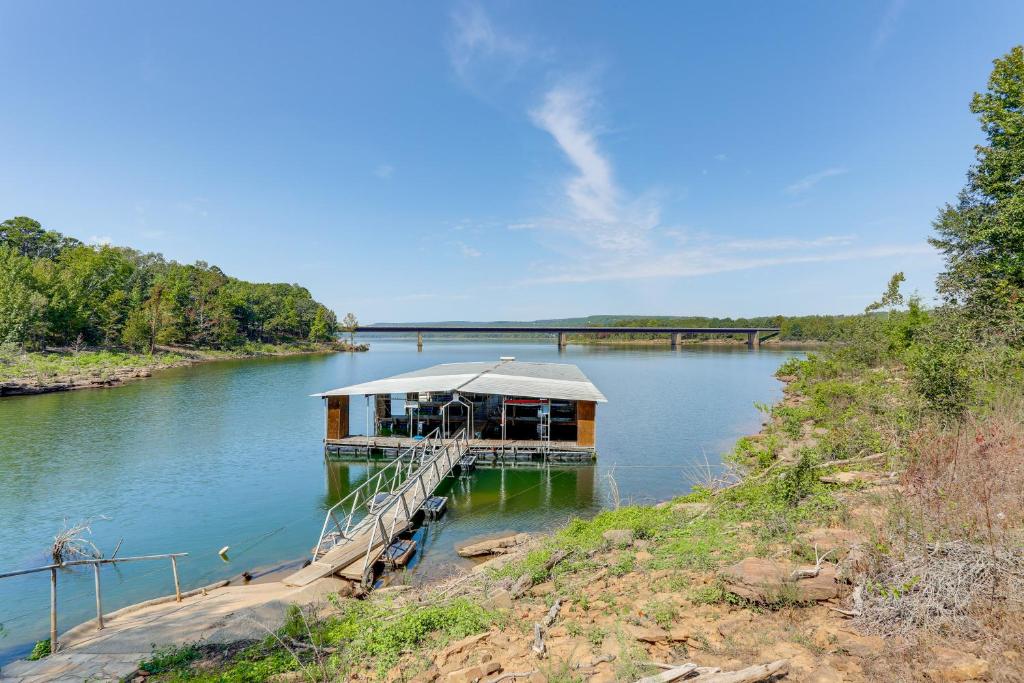 a house on a dock in the middle of a river at Walk to Greers Ferry Lake! Home with Dock Access in Greers Ferry