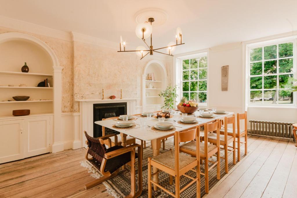 ein Esszimmer mit Tisch und Stühlen und einem Kamin in der Unterkunft Georgian Luxury Margate Tnhouse Sleeps 11 By Adliv in Margate