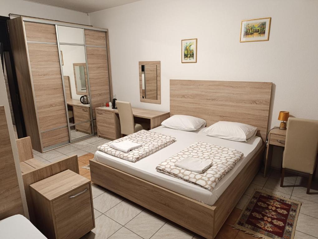 een slaapkamer met een bed, een tafel en een bureau bij Hostel Centrum in Mostar