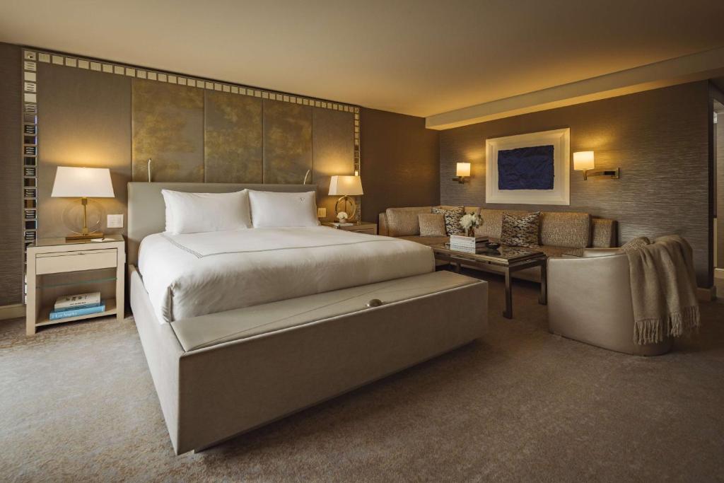 a bedroom with a large bed and a living room at L'Ermitage Beverly Hills in Los Angeles