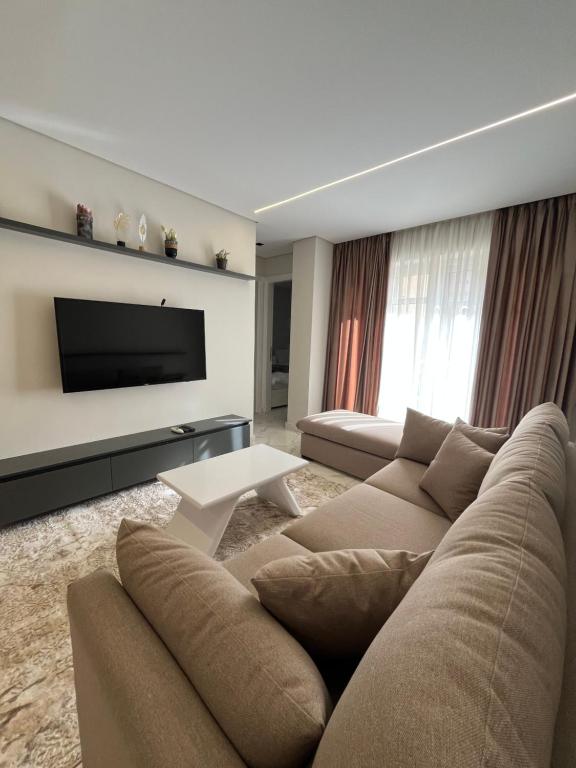 a living room with a couch and a flat screen tv at Evoke suites apartment in central madinaty 2 bedroom in Madinaty