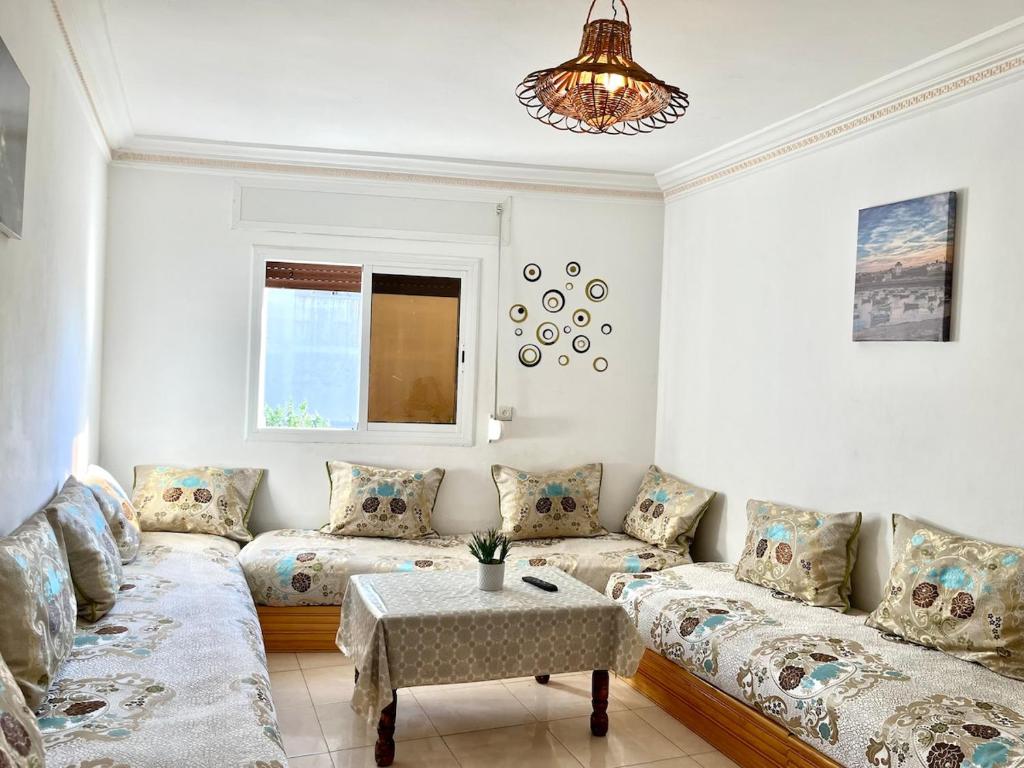 una sala de estar con un sofá y una mesa en Mamoun allawii, en Asilah