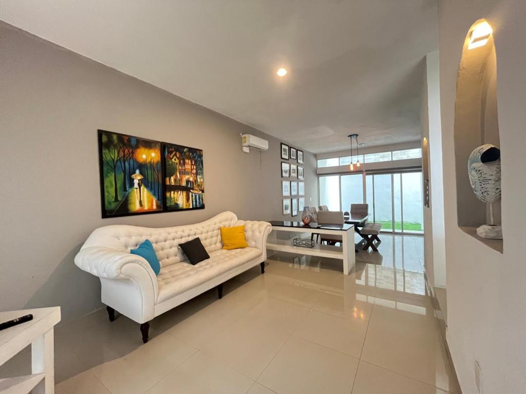 Confortable casa en Cozumel, cerca del mar #10 في كوزوميل: غرفة معيشة مع أريكة بيضاء وطاولة