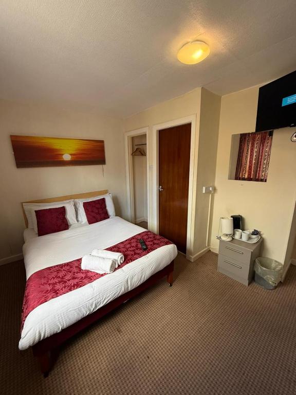 ein Schlafzimmer mit einem großen Bett mit rot-weißer Bettwäsche in der Unterkunft VERNON Hotel in Blackpool