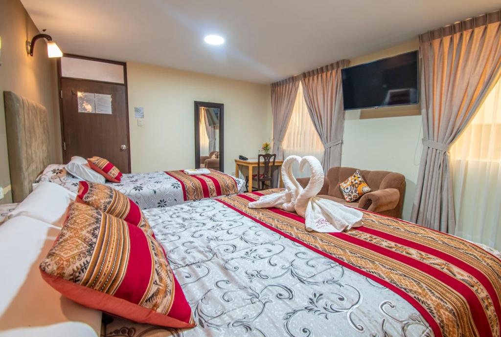 a hotel room with two beds with towels on them at Los Portales de Chivay Hotel in Chivay