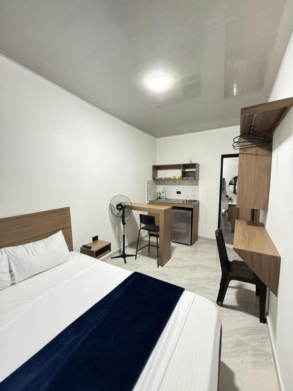 a bedroom with a bed and a desk with a chair at Coliving C33- Apartaestudios En Palmira Centro in Palmira