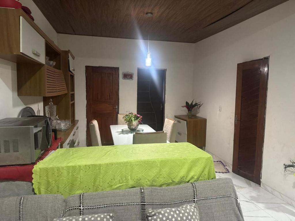 un soggiorno con un tavolo con una tovaglia verde di casa paraíso a Marituba