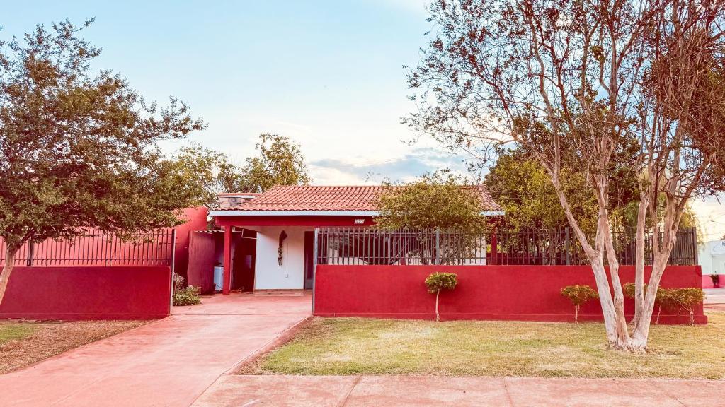 a red fence in front of a red house at Casa Grande e Completa - Emite NF in Maracaju