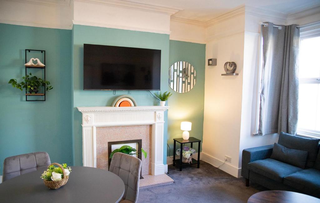 een woonkamer met een open haard en een tv aan de muur bij The Channel View, 4 bedrooms, 4 beds, FREE parking, 3 minutes from the beach in Eastbourne