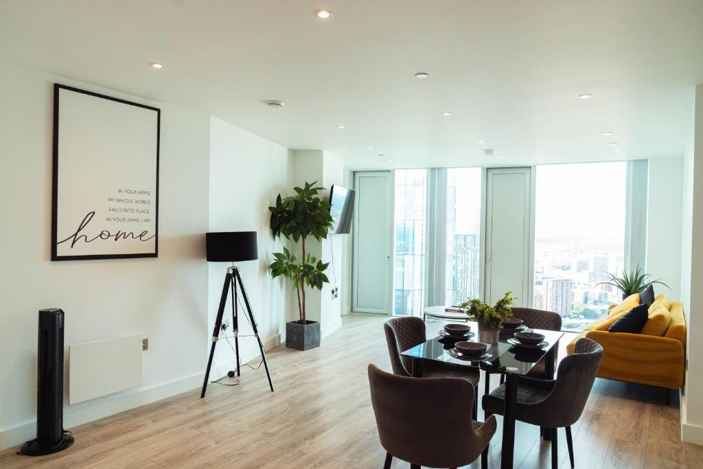 een woonkamer met een tafel en stoelen bij Luxury 2 Bed apartment Deansgate in Manchester