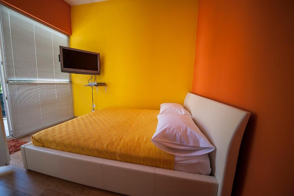 a bedroom with a bed with a yellow wall at Apartment May in Mali Lošinj