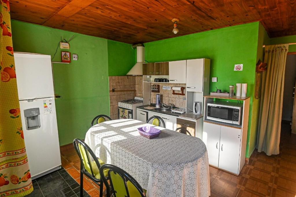 a kitchen with a table and a green wall at Tu refugio en Caleta Olivia in Caleta Olivia