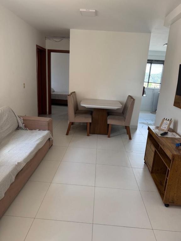 a bedroom with a bed and a table and chairs at Seu apartamento em Ilhéus in Ilhéus