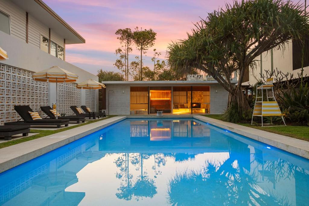 a swimming pool in the backyard of a house at Your Own Luxury Coastal Beachfront Wellness Retreat 14 sleeps in Casuarina