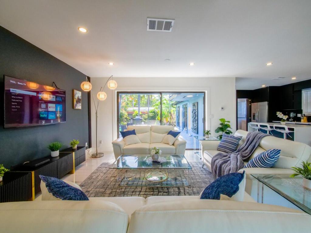 Una sala de estar con sofás blancos y una cocina. en Luxury,3Bed 2Bath ,Pool,Grill,Parking in Hollywod, en Hollywood