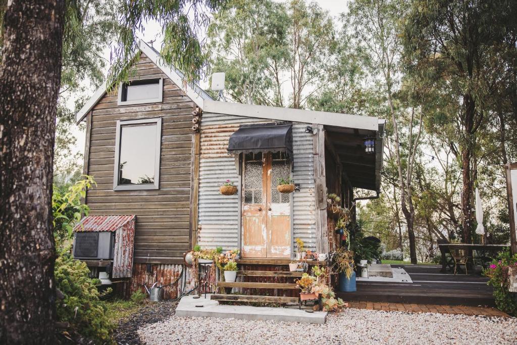 a tiny house in the woods with a door at The Cabin, Ghost Gum Gully in Thornton