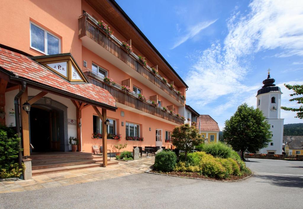 a building with a clock tower in front of it at Ferienzimmer Paunger in Miesenbach