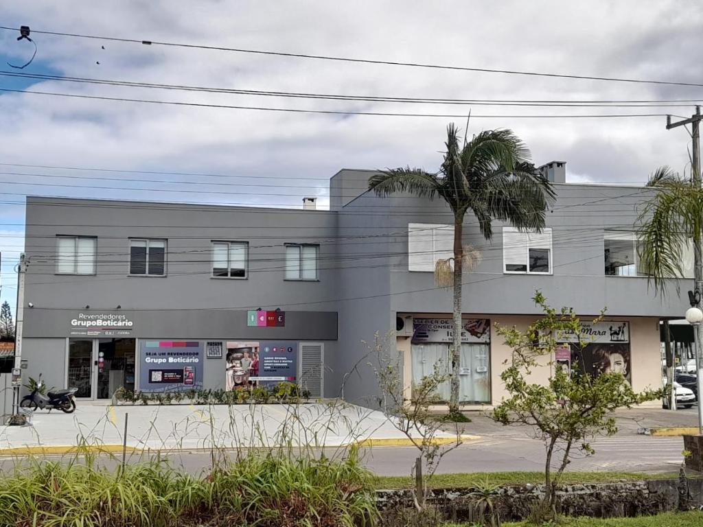 ein Gebäude mit einer Palme davor in der Unterkunft Casa Amarela in Torres