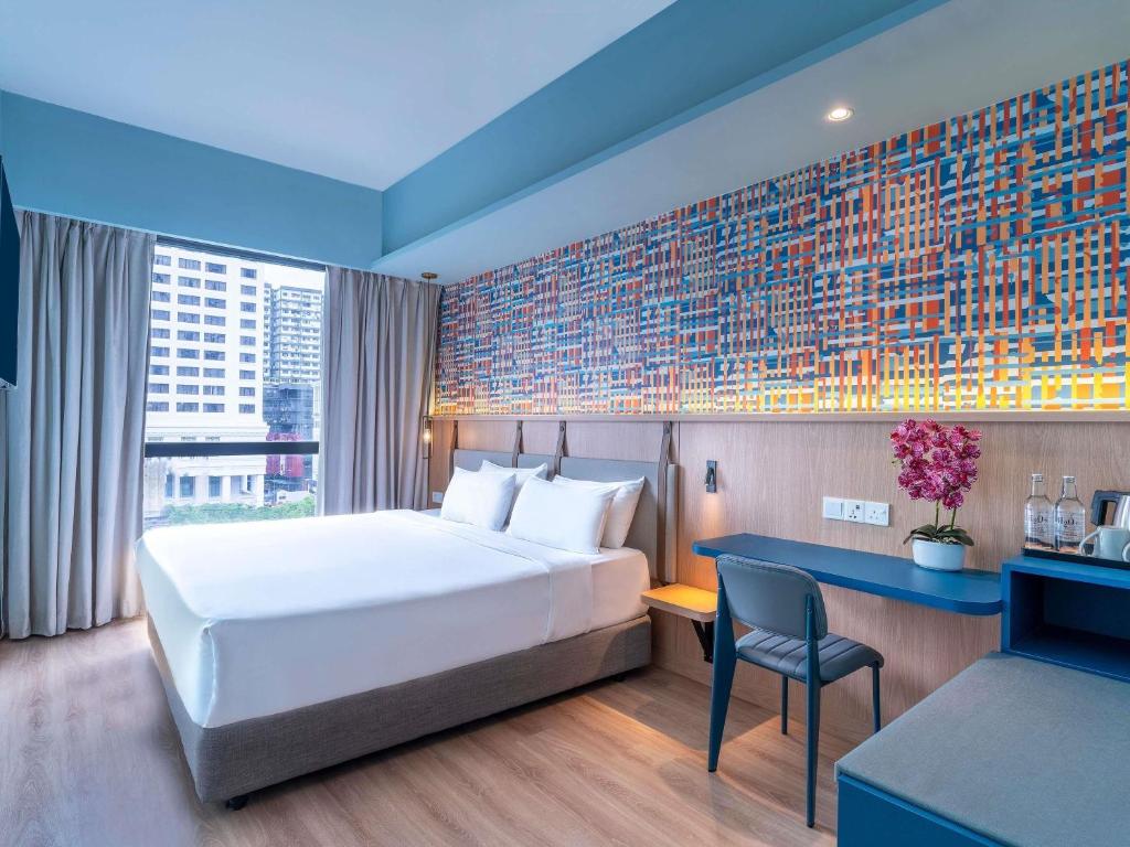 a hotel room with a bed and a desk and a chair at ibis Styles Kuala Lumpur Bukit Bintang in Kuala Lumpur