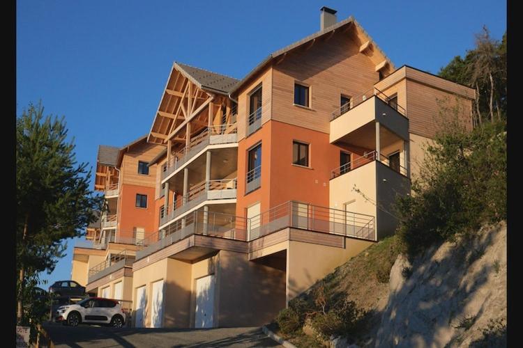 Un gran edificio con un coche aparcado delante. en Chorges Lakeside Stay with a Fireplace, en Grand PrÃ©