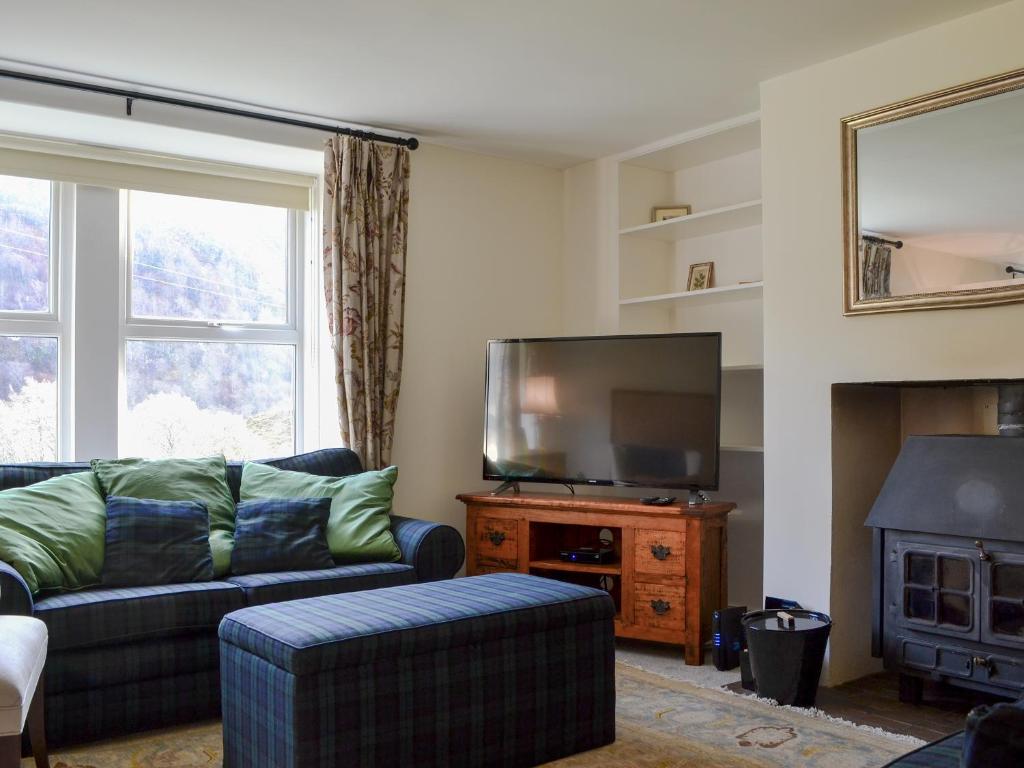 a living room with a couch and a flat screen tv at Glenmeanich Cottage - Uk33789 in Bridgend