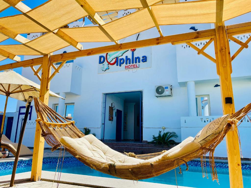 una hamaca frente a un edificio con piscina en Dolphina hotel & Restaurant, en Dahab