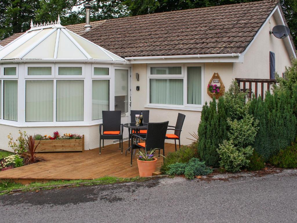 un patio con tavolo e sedie di fronte a una casa di Tyglyn Cottage a Lampeter