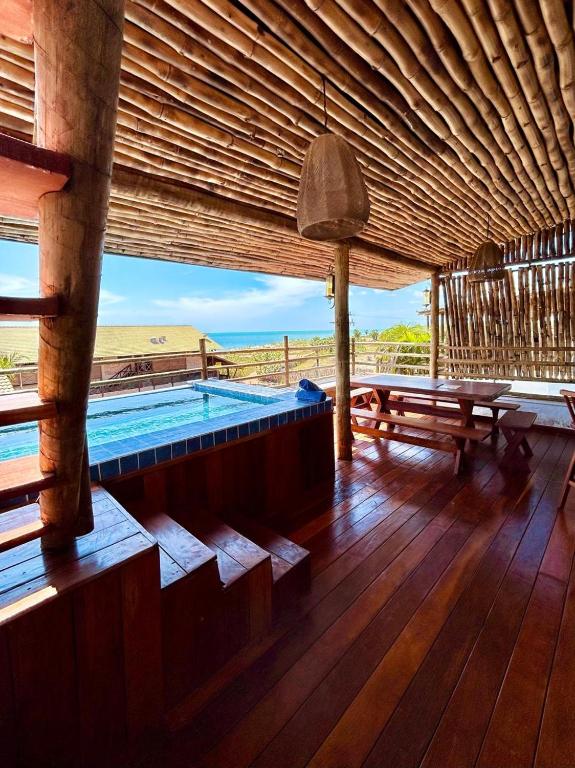 a room with a pool and a table and benches at Bali BG Casa Bamboo in Barra Grande