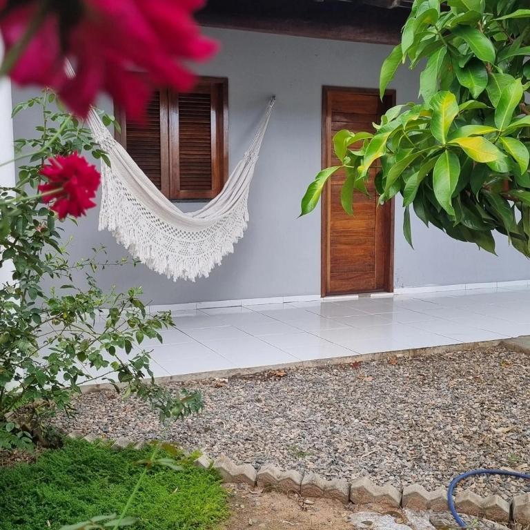 a house with a hammock in front of a door at Casa 03 in Parnaíba