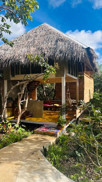 a house with a thatched roof and a pathway at Chalet, Free Suzuki Jimny 4x4, Port pick-up and drop-off service, and Unlimited Massage Chair Use in Maria
