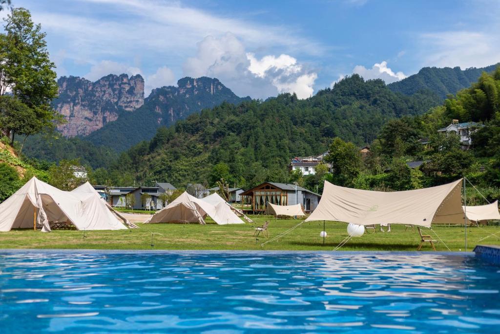 a group of tents and a pool of water at Glamping Resort-At National Forest Park with Free Shuttle in Zhangjiajie