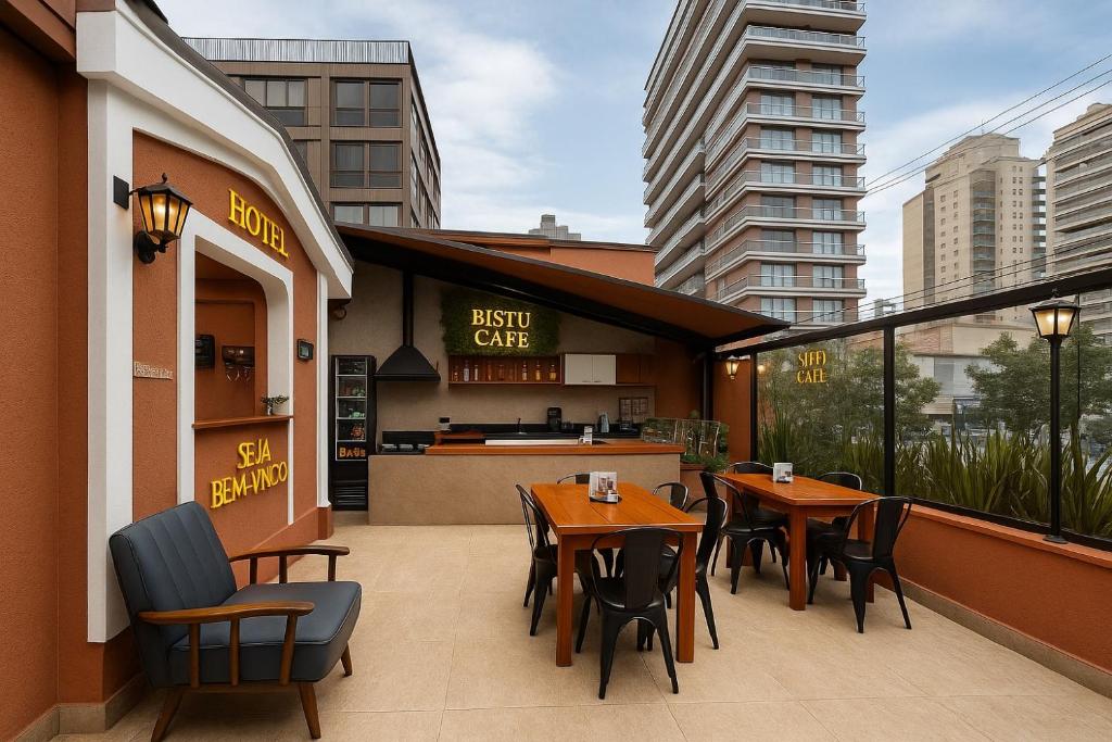 a restaurant with tables and chairs on a balcony at Bistu Hotel - Vila Nova Conceição in São Paulo