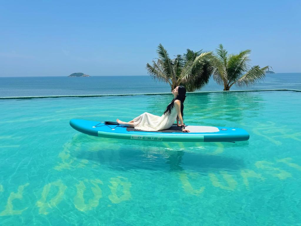 een vrouw op een surfplank in het water bij Cloud Coast Hotel in Kang-k'ou