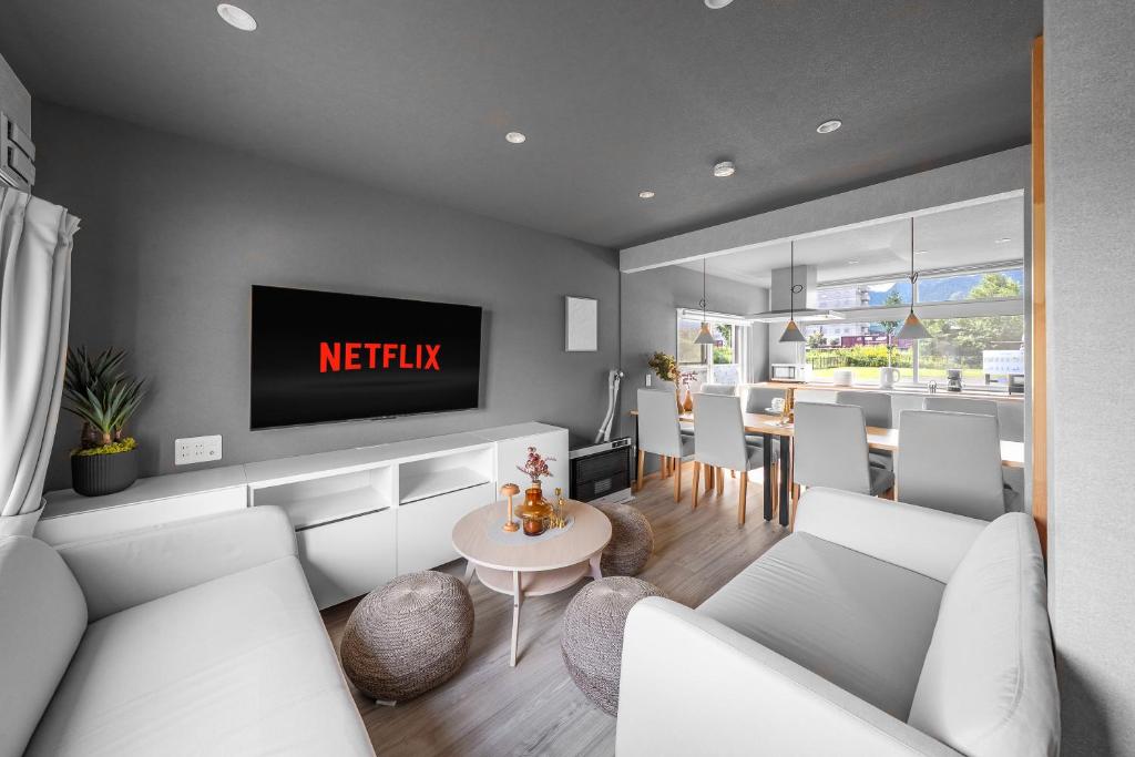 富良野市にあるThe ARBANOの壁にテレビが取り付けられたリビングルーム