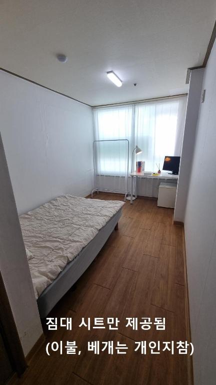 a bedroom with a bed in the corner of a room at Huestay Gumdan in Incheon
