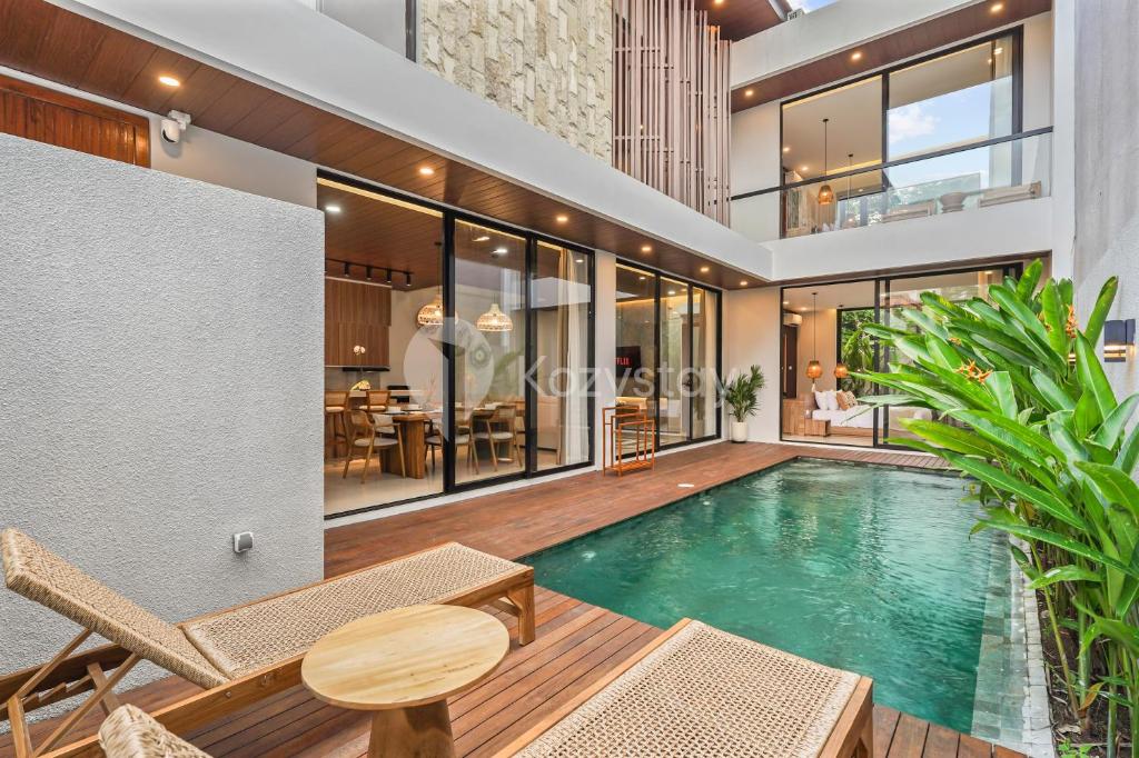a swimming pool in a villa with a house at Santari Villa by Kozystay - Canggu in Pererenan