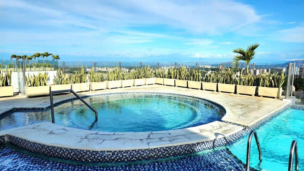 una piscina en un complejo con palmeras en Moderno y amplio apartamento cerca a centros comerciales, en Ibagué