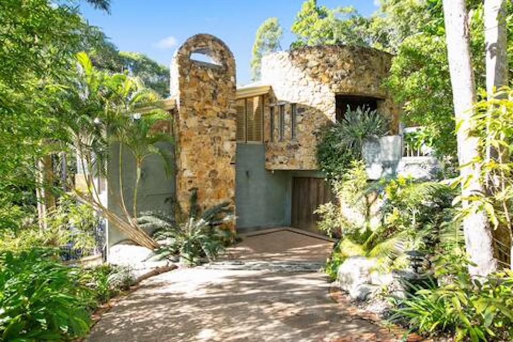 an old stone house with a driveway and trees at Little Cove 4BR Home, Pool, Pool table, Sleeps 16 in Noosa Heads
