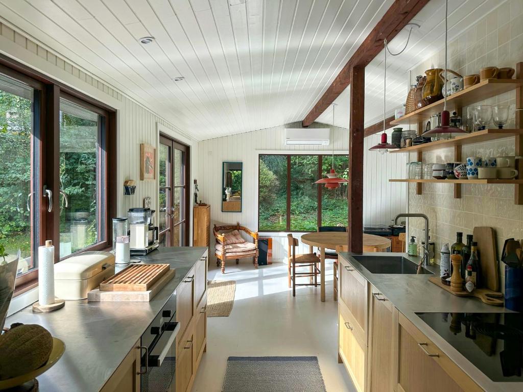 a kitchen with a large counter and a dining room at Nordic-Style Summer House At Asserbo Plantage in Melby