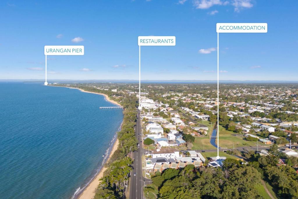 een luchtfoto van de kustlijn van een strand met drie hoge windturbines bij Bay Breeze Beachhouse in Scarness