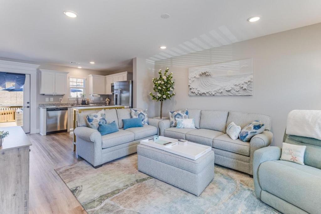 a living room with two couches and a kitchen at Front row Seat at 'The Sandy Rose' in Biloxi
