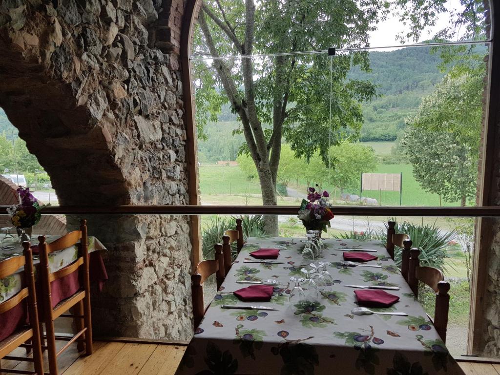 una mesa en una habitación con una ventana grande en Hotel rural La soleia d'Oix, en Oix