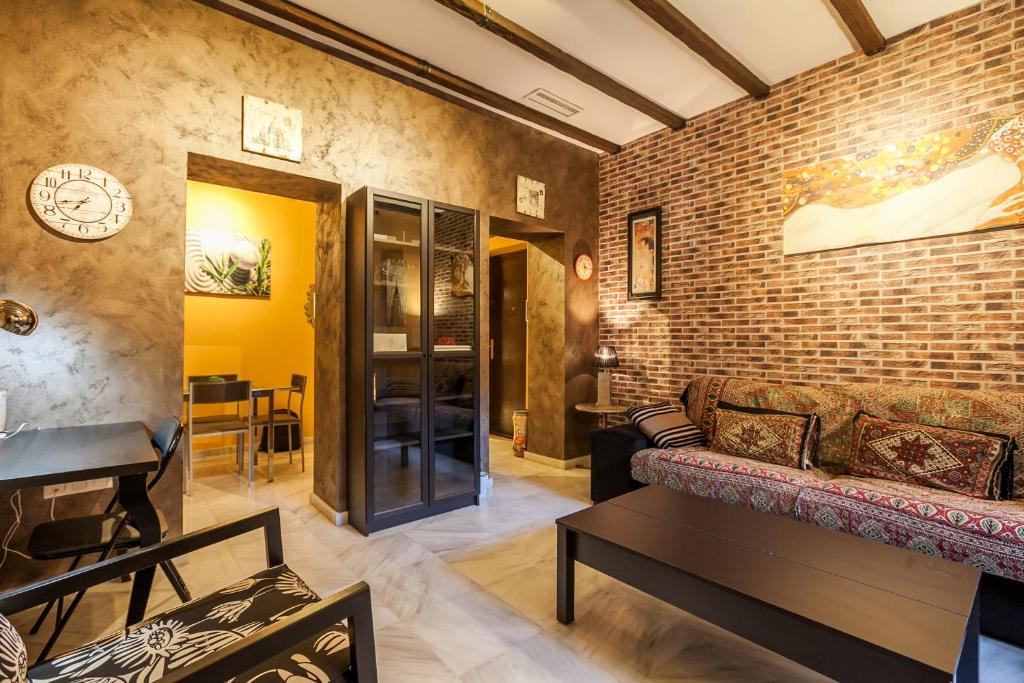 a living room with a brick wall and a couch at SevillaHome -Alfareria in Seville