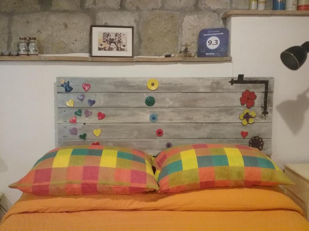 a bedroom with a wooden headboard and two pillows at Apartment Seminello in Pitigliano