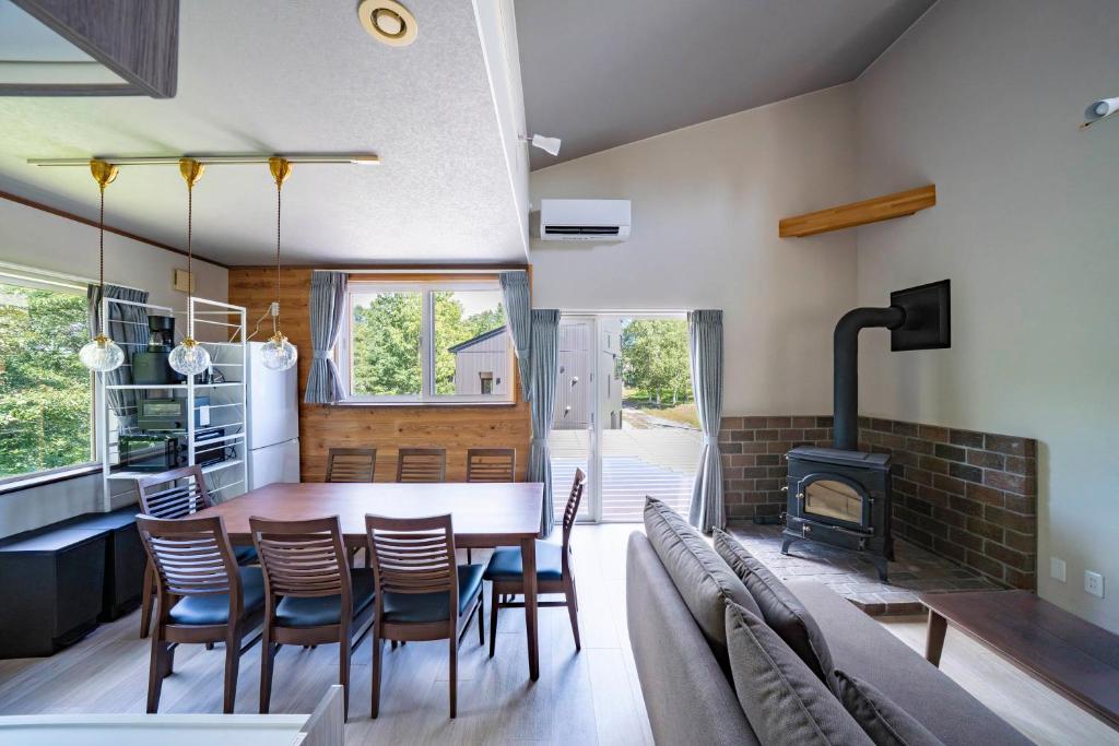 a kitchen and dining room with a table and a fireplace at Niseko Mt Village in Niseko