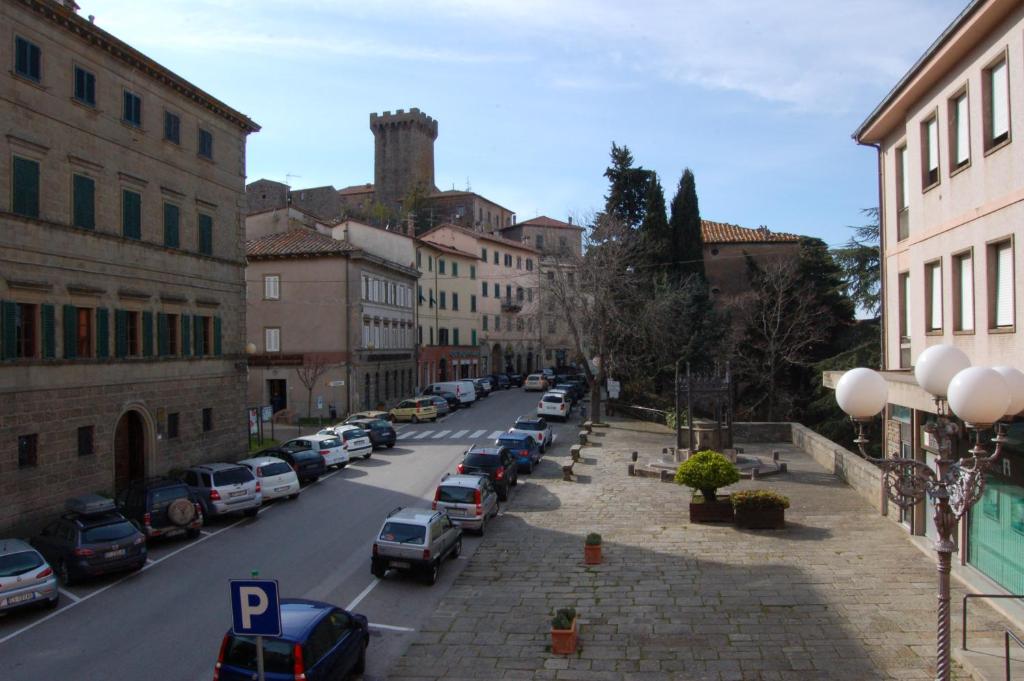 una calle de la ciudad con coches estacionados al costado de la carretera en Affittacamere Le Fonti, en Arcidosso