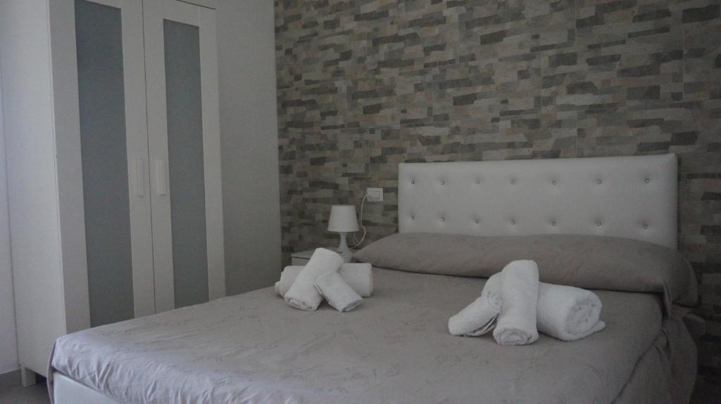 Un dormitorio con una cama con toallas blancas. en Marselo B&B, en Bari