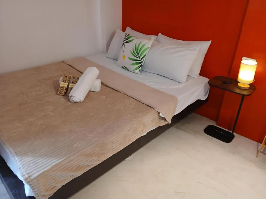 a small bed with two pillows and a candle on it at Silid Siargao in General Luna