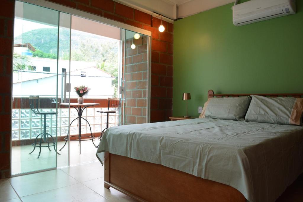 een slaapkamer met een bed en een groene muur bij Pousada Ilha Maravilha in Rio de Janeiro