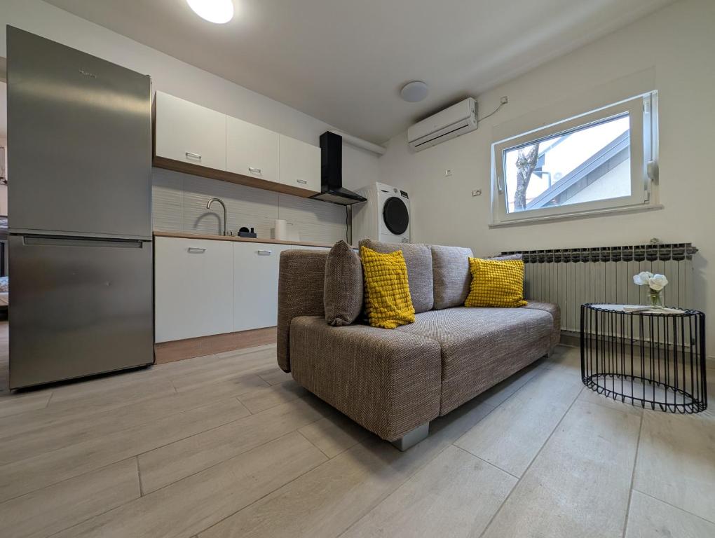 a living room with a couch and a kitchen at Cozy Apartment with Washer, Dryer, and Floor Heating in Sesvete